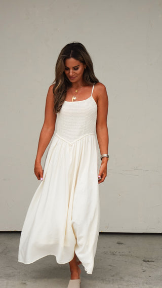 Woman wearing the Natural Smocked Midi Dress, a warm-weather women's midi dress from COCO The Shop Dublin Ohio