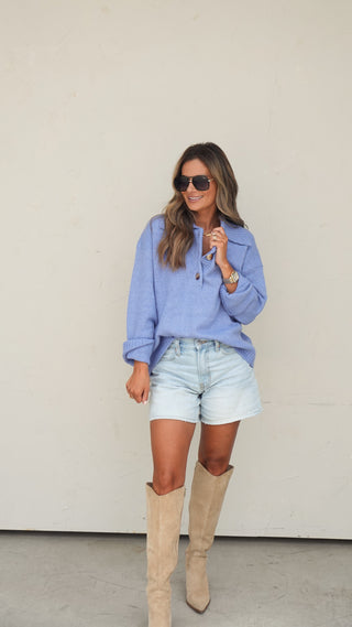 Women's blue collared slouchy knit sweater styled with light wash denim shorts