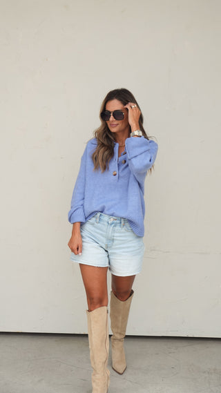 Women's blue collared slouchy knit sweater styled with light wash denim shorts