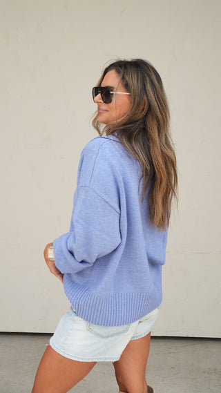 Women's blue collared slouchy knit sweater styled with light wash denim shorts