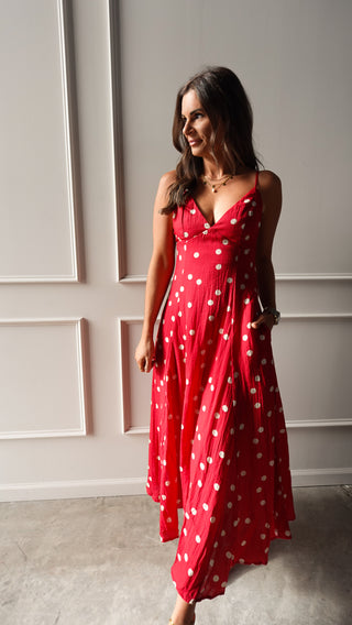 Model wearing a red polka dot midi dress with thin straps