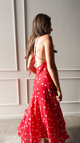 Model wearing a red polka dot midi dress with thin straps
