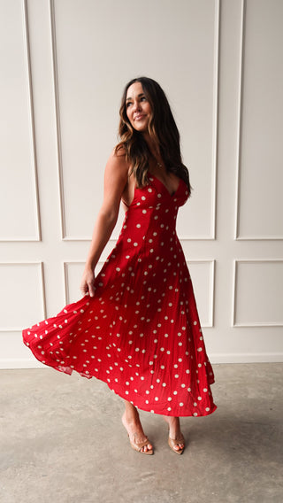 Model wearing a red polka dot midi dress with thin straps