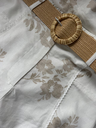 Close-up of a fabric with floral patterns and a woven belt.